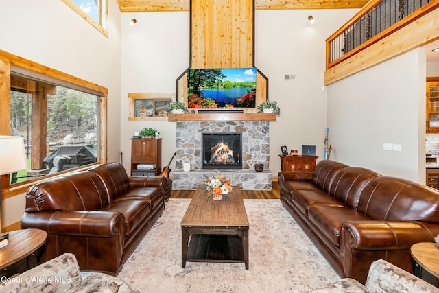 living room with wood-type flooring, a fireplace, and a towering ceiling