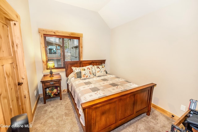 bedroom featuring light colored carpet and vaulted ceiling