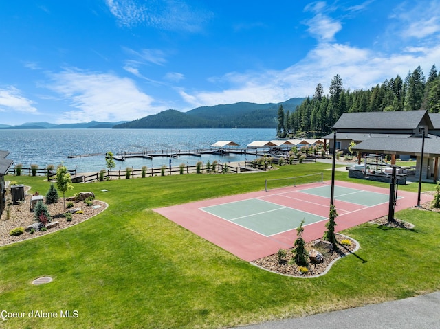 view of sport court featuring basketball court, a yard, and a water and mountain view