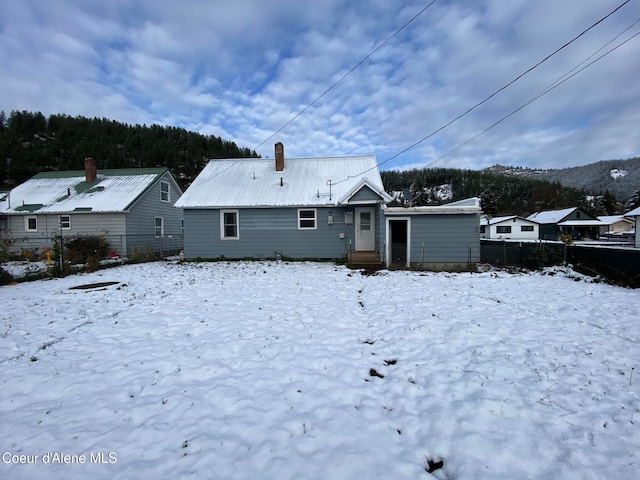 view of snow covered back of property