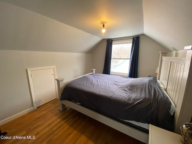 bedroom featuring wood-type flooring and vaulted ceiling