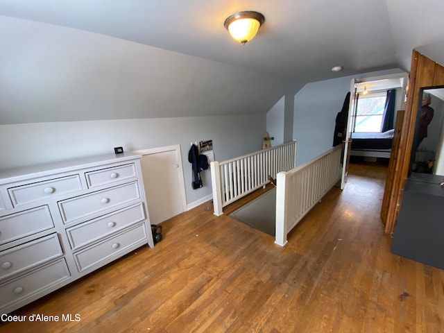 additional living space with hardwood / wood-style floors and vaulted ceiling