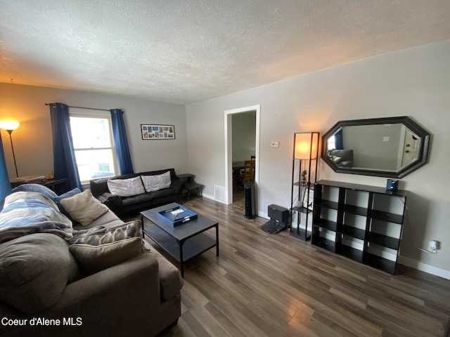 living room with dark hardwood / wood-style flooring and a textured ceiling