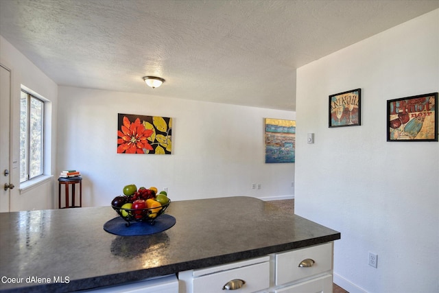 kitchen featuring white cabinets and a textured ceiling