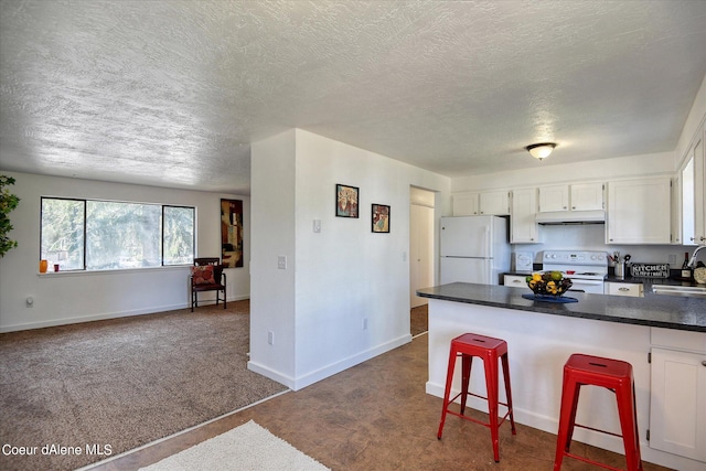 kitchen with white cabinetry, white appliances, a breakfast bar area, and dark carpet