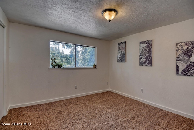 empty room featuring carpet and a textured ceiling