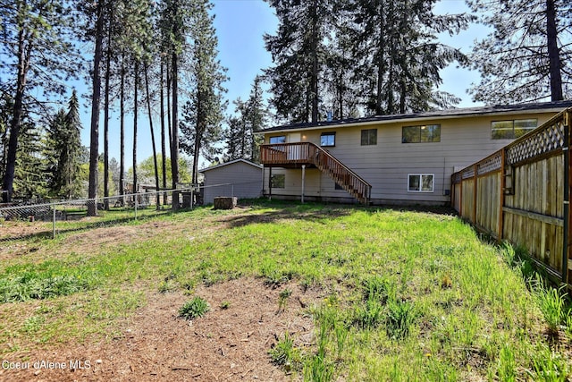 rear view of house with a deck and a yard