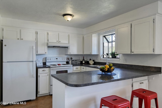 kitchen featuring a breakfast bar, white appliances, sink, kitchen peninsula, and white cabinetry