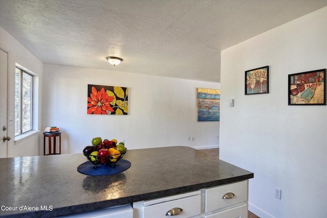 kitchen with white cabinets and a textured ceiling