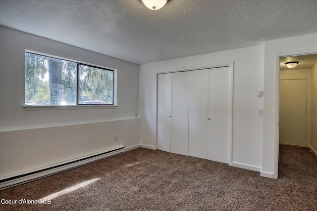 unfurnished bedroom with a closet, carpet floors, a textured ceiling, and a baseboard heating unit