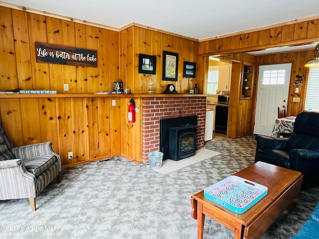 living room featuring carpet flooring, wood walls, a wood stove, and crown molding