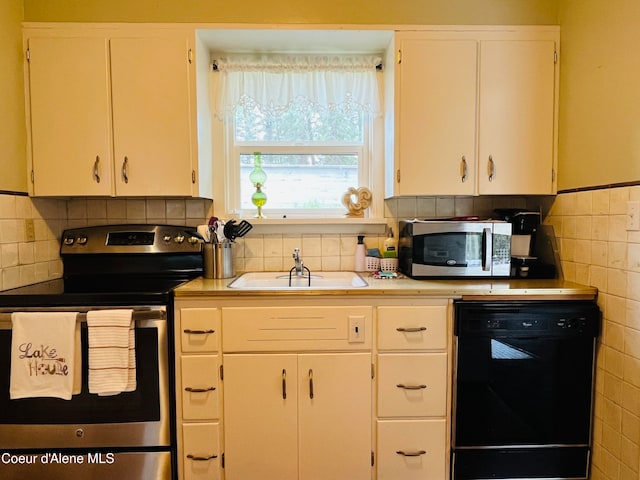 kitchen with appliances with stainless steel finishes, tasteful backsplash, white cabinetry, and sink