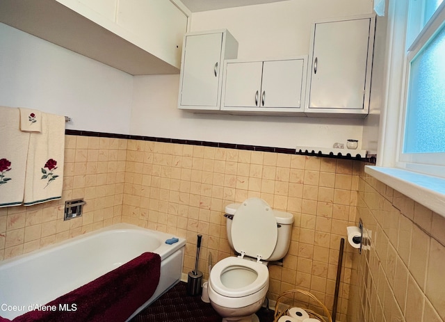 bathroom featuring a bathtub, tile patterned flooring, tile walls, and toilet