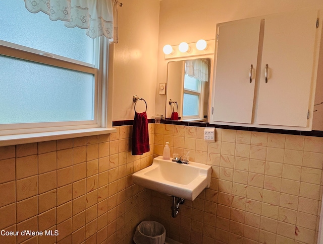 bathroom with sink and tile walls