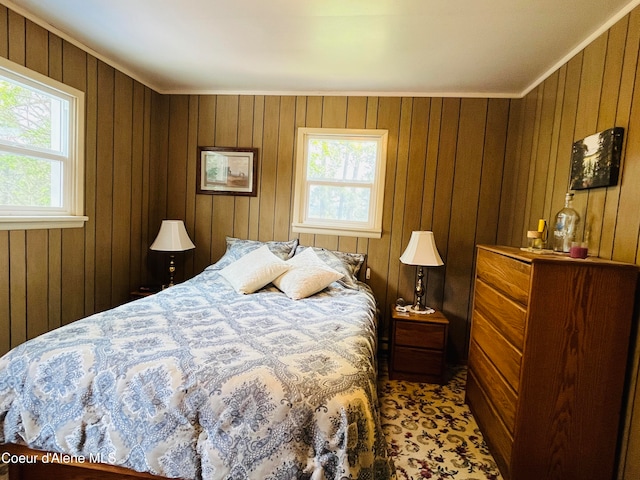 bedroom with ornamental molding and wooden walls