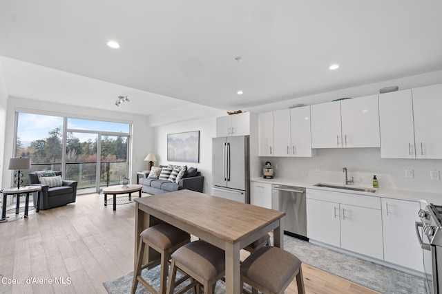 kitchen featuring white cabinets, light hardwood / wood-style floors, sink, and appliances with stainless steel finishes