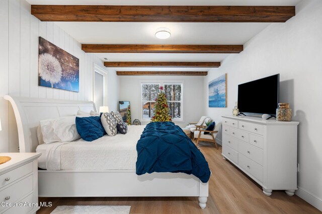 bedroom with beamed ceiling and light wood-type flooring