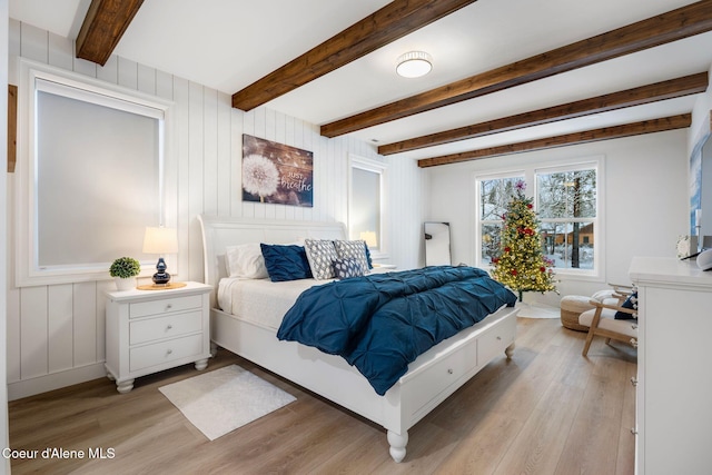 bedroom featuring beam ceiling and light wood-type flooring