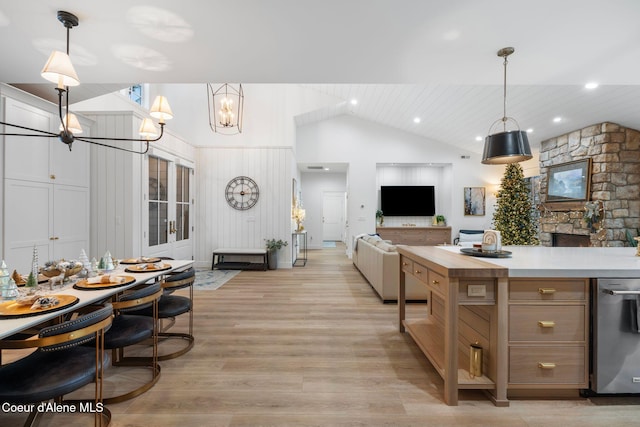 kitchen with a fireplace, light hardwood / wood-style floors, hanging light fixtures, and a chandelier