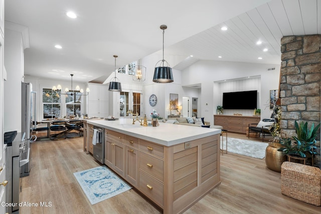 kitchen with a large island, stainless steel appliances, hanging light fixtures, and light hardwood / wood-style flooring