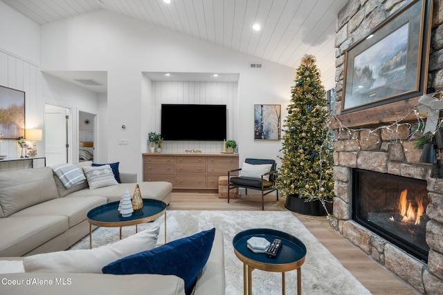 living room featuring a fireplace, wooden ceiling, vaulted ceiling, and light wood-type flooring