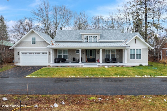 view of front of home with a porch, a garage, and a front lawn