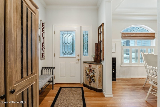 entryway with light hardwood / wood-style floors and ornamental molding