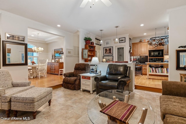 living room featuring ceiling fan with notable chandelier, light wood-type flooring, and crown molding