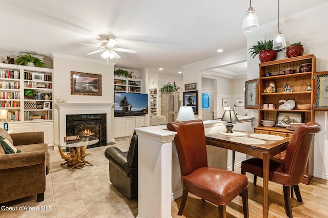 living room featuring a high end fireplace, light wood-type flooring, built in features, and ornamental molding