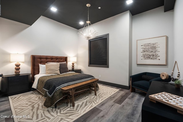 bedroom with a chandelier, baseboards, and wood finished floors