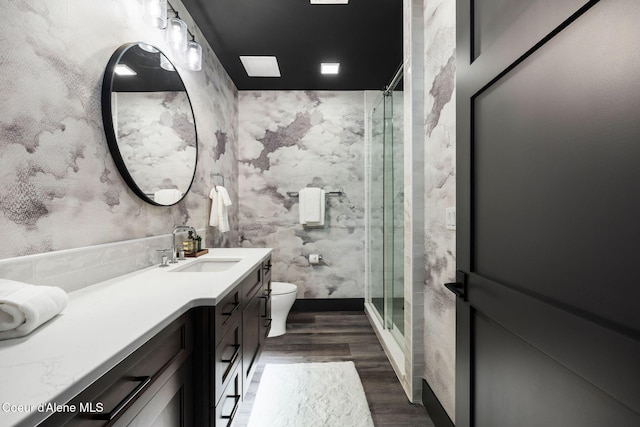 full bath featuring a stall shower, vanity, toilet, and wood finished floors