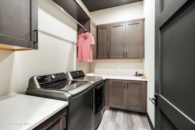 washroom featuring cabinet space, separate washer and dryer, and light wood finished floors