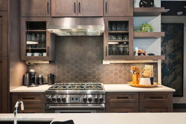 kitchen with dark brown cabinetry, light countertops, high end range, range hood, and open shelves