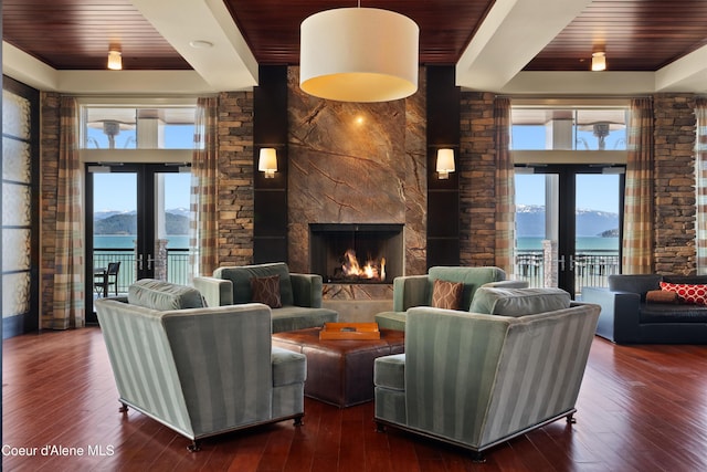 living area with a healthy amount of sunlight, a mountain view, and french doors