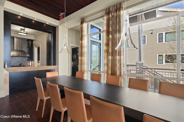 dining area featuring ornamental molding, wood ceiling, and dark wood finished floors