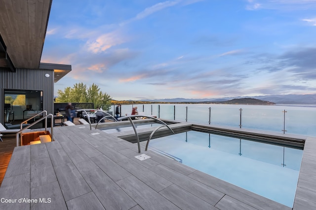 exterior space with a dock and a water and mountain view