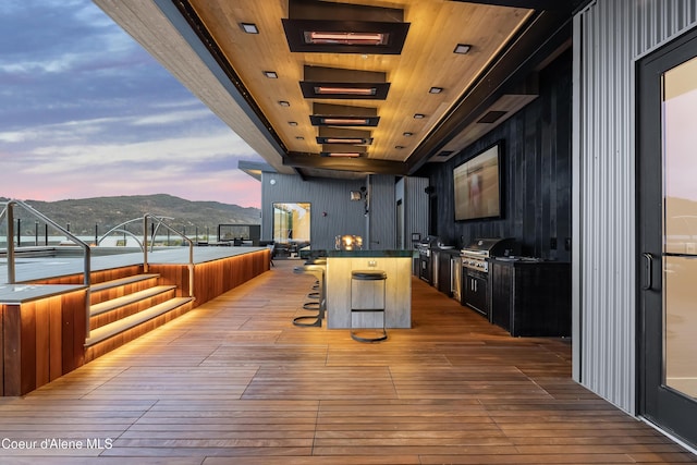 deck at dusk featuring grilling area and area for grilling