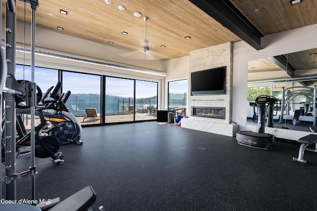 exercise room with ceiling fan, wooden ceiling, a fireplace, and recessed lighting