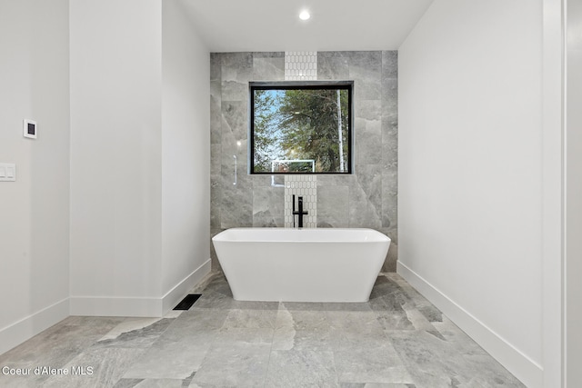 bathroom featuring a bathing tub and tile walls