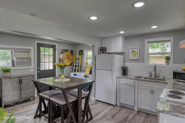 kitchen with white appliances, light hardwood / wood-style flooring, white cabinetry, and sink