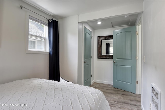 unfurnished bedroom with light wood-type flooring and heating unit