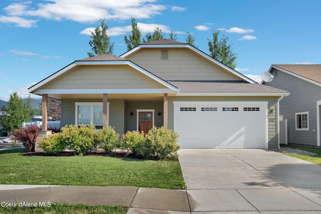 view of front of property featuring a porch, a garage, and a front lawn