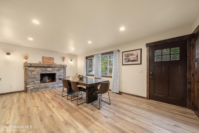 dining area with a fireplace and light hardwood / wood-style floors