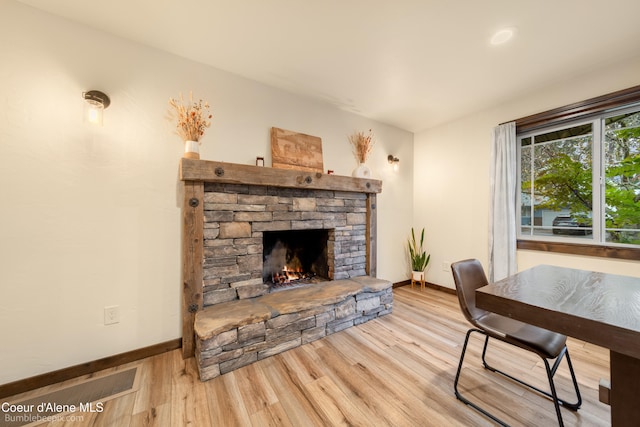 office area with a fireplace and light wood-type flooring