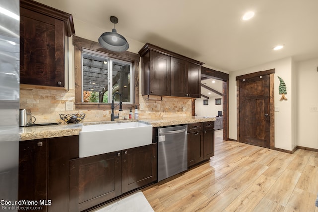 kitchen featuring light stone countertops, decorative backsplash, stainless steel appliances, sink, and light hardwood / wood-style floors