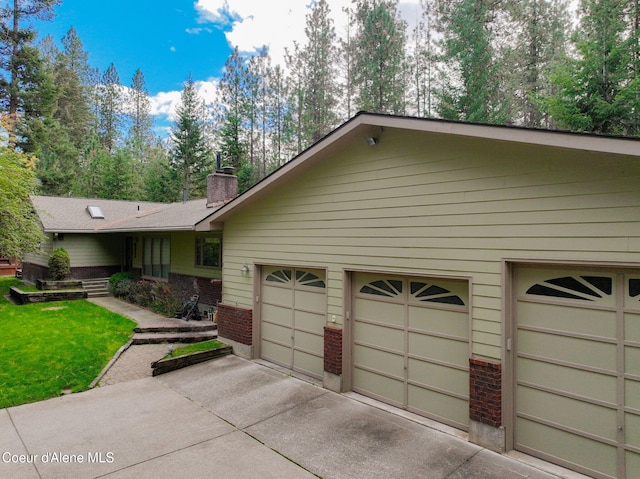 694 S Signal Point Rd, Post Falls, ID 83854 - single story home with brick siding, a chimney, a garage, and driveway