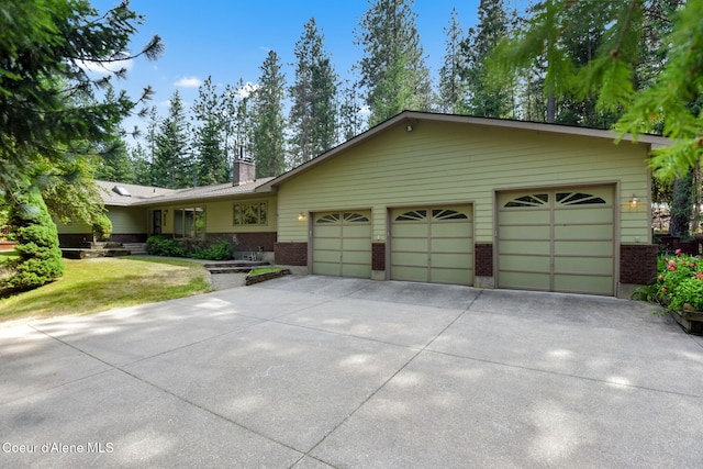 694 S Signal Point Rd, Post Falls, ID 83854 - ranch-style house featuring brick siding, driveway, an attached garage, a chimney, and a front lawn