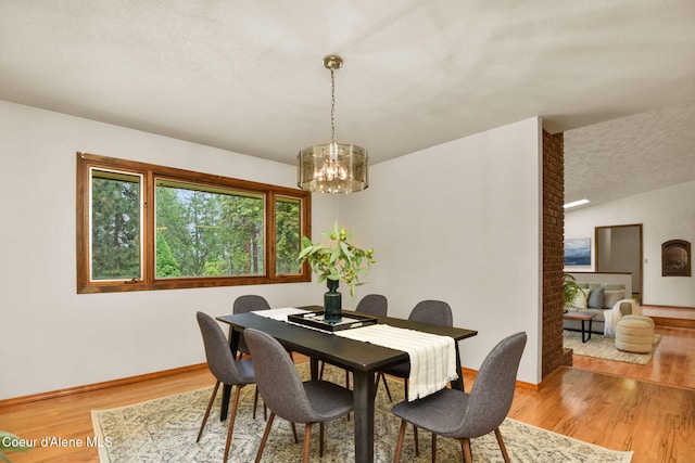 694 S Signal Point Rd, Post Falls, ID 83854 - dining room featuring a chandelier, wood finished floors, and a textured ceiling