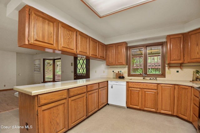 694 S Signal Point Rd, Post Falls, ID 83854 - kitchen with white dishwasher, a peninsula, tasteful backsplash, and light countertops