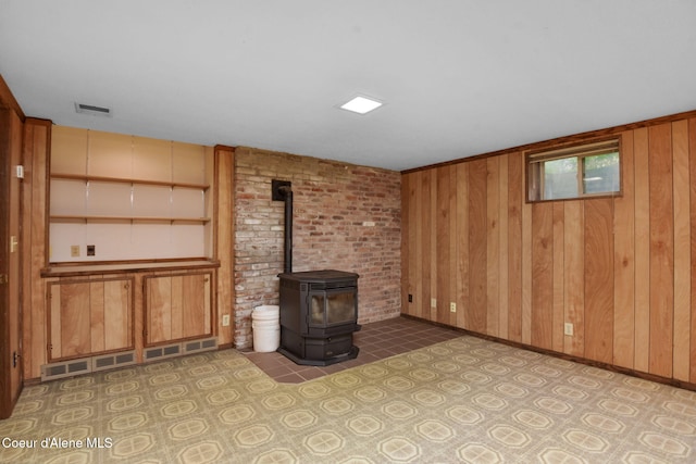 694 S Signal Point Rd, Post Falls, ID 83854 - unfurnished living room with wood walls and a wood stove